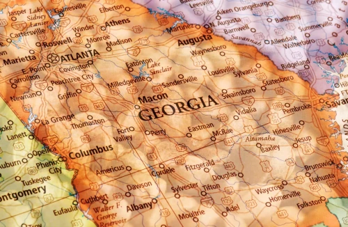 A map of Georgia on top of an image of Cannabis seeds