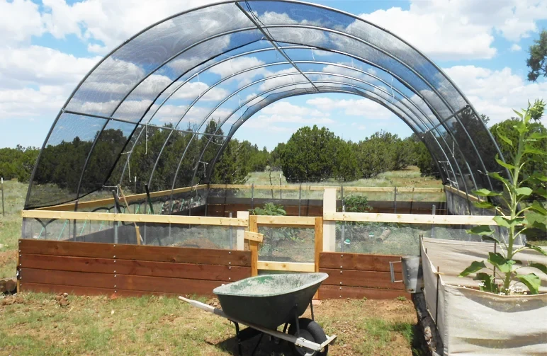 A DIY garden hoop house in an arid desert environment using 30% shade cloth to shield plants from extreme heat and high UV rays, a setup recommended for Texas growers.